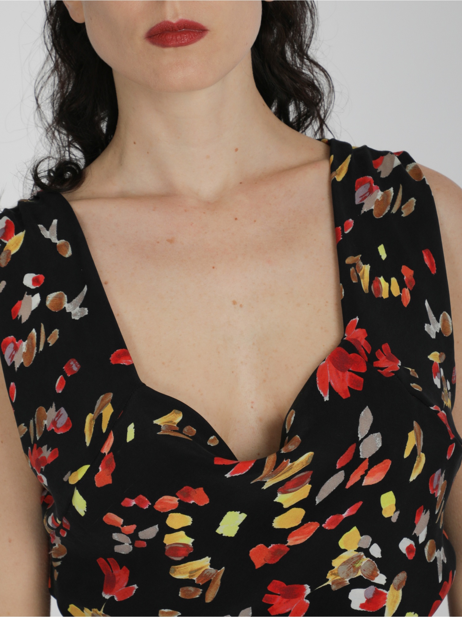 Woman long black soft dress in floral pattern without sleeves with square neckline and ties at the waist. Black, red and yellow color. 100% cupro, made in Italy. Find out online!